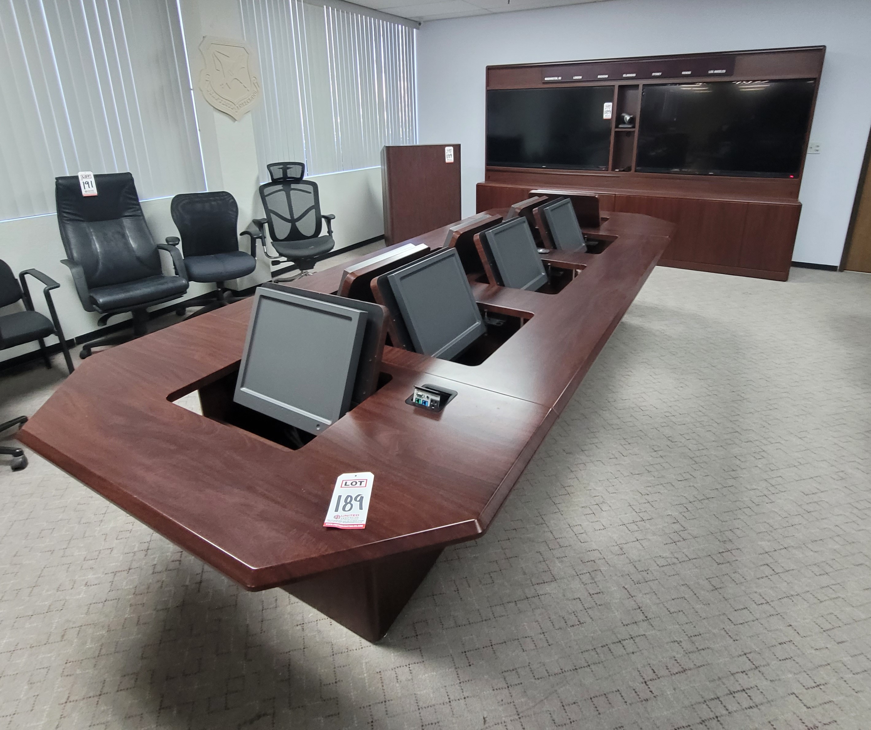 LOT - CONFERENCE ROOM GROUPING: CONFERENCE TABLE W/ FLIP-PANELS FOR MONITORS, AUDIO VIDEO CABINET W/ (2) 65" LCD SCREENS AND DIGITAL TIME ZONE CLOCK, FREESTANDING PODIUM, COLOR: MAHOGANY-189