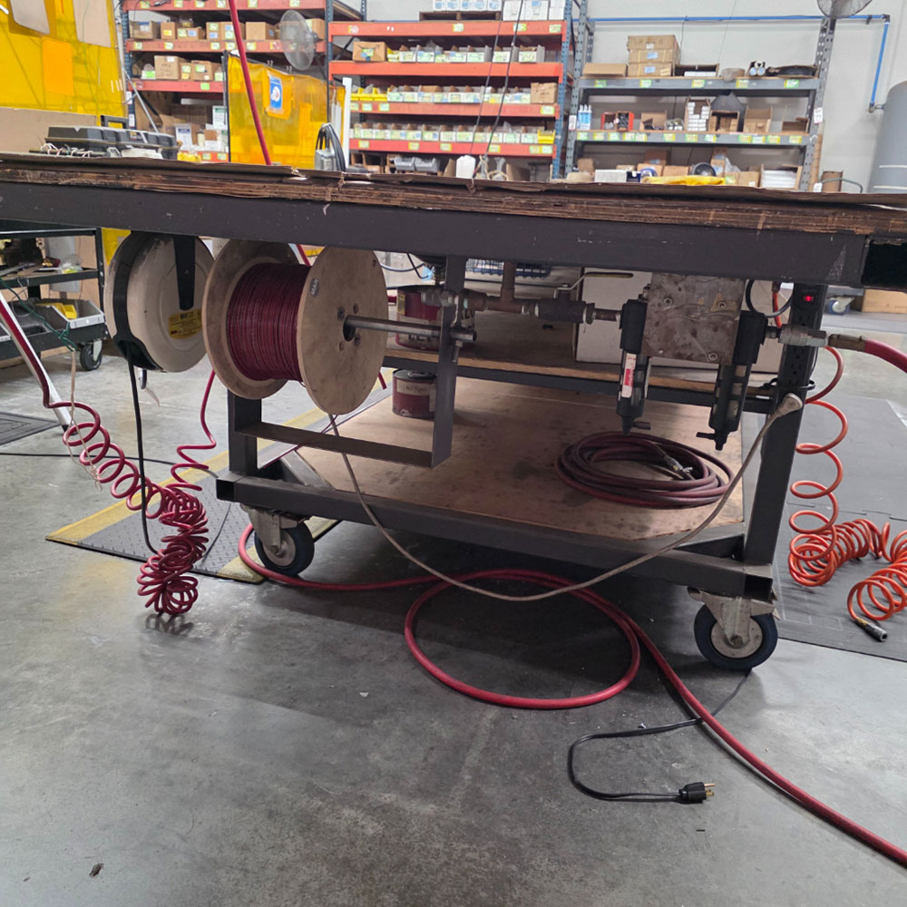 STEEL TABLE ON CASTERS W/ 14' X 4' PLYWOOD TOP, 37" TOP HT, CONTENTS NOT INCLUDED-173