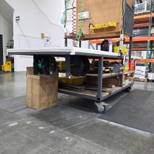 STEEL ASSEMBLY TABLE ON CASTERS, W/ 11' X 4' WOOD TOP, 37" TOP HT, W/ CENTER STORAGE & LIGHTS, CONTENTS NOT INCLUDED-174