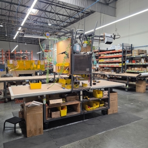 STEEL ASSEMBLY TABLE ON CASTERS, W/ 11' X 4' WOOD TOP, 37" TOP HT, W/ CENTER STORAGE & LIGHTS, CONTENTS NOT INCLUDED-174