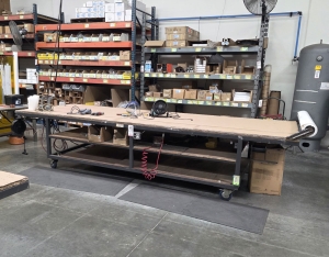 STEEL TABLE ON CASTERS W/ 14' X 5' PLYWOOD TOP, 37" TOP HT, CONTENTS NOT INCLUDED-177