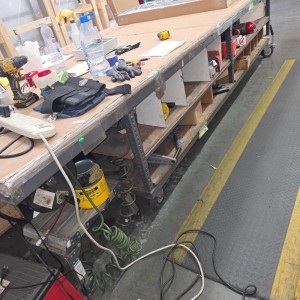 STEEL TABLE ON CASTERS W/ 14' X 5' WOOD TOP, CONTENTS NOT INCLUDED-215