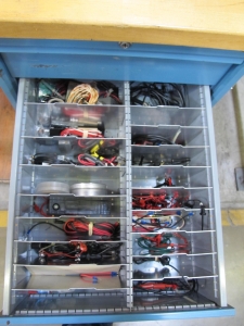 LISTA INDUSTRIAL WORK DESK, BUTCHER BLOCK TABLE TOP SHELF 48"L X 30"W, 4 DRAWER CABINET WITH CONTENTS TO INCLUDE: MISC. TEST CABLES AND WIRE, WIRE BRUSHES. LOADING & HANDLING $15-1673