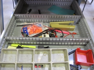 LISTA INDUSTRIAL WORK DESK, BUTCHER BLOCK TABLE TOP 60"L X 30"W, 5 DRAWER CABINET WITH CONTENTS TO INCLUDE: MISC. OFFICE SUPPLIES, EAR PLUGS, SAFETY GLASSES, ELECTRIC TEST WIRE, . LOADING & HANDLING $15-1693